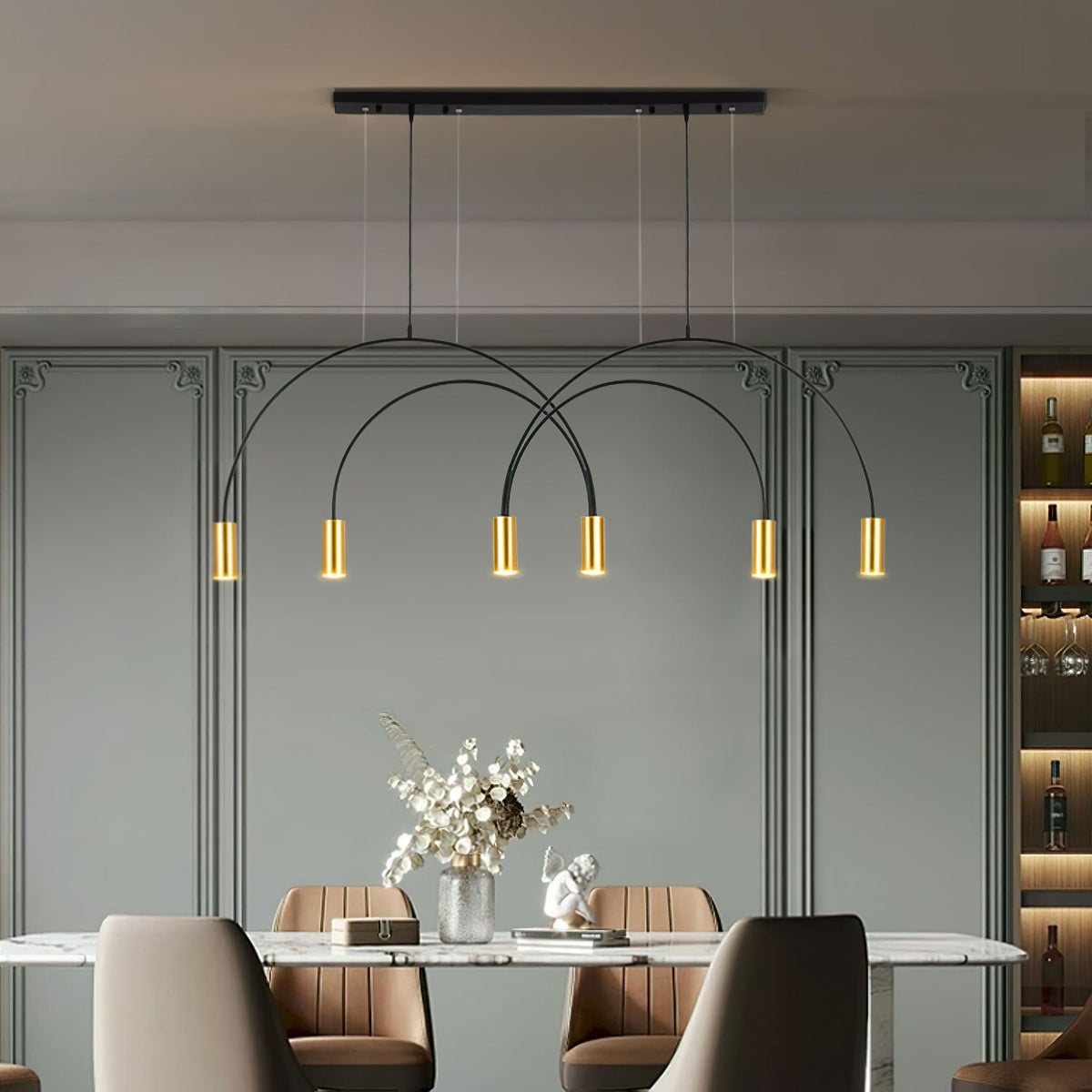Above a marble dining table, this Clérachic pendant light hangs from a black canopy bar with six brass spot heads, against a sage-green panelled wall.