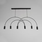Black Clérachic arch pendant against a plain grey wall, its six spot heads hanging at staggered heights below the canopy bar.