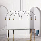 Black arches and brass spot heads on this Clérachic pendant, framed by two white archways above a glass dining table.