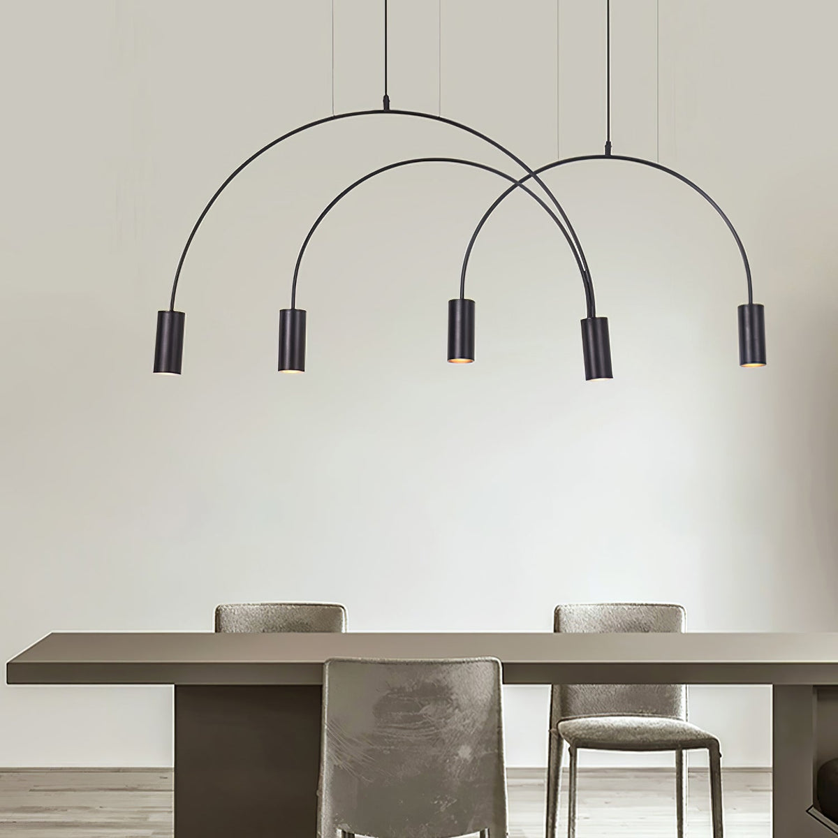 Five black spot heads on crossing arches, this Clérachic pendant hangs above a dark table and grey velvet chairs.