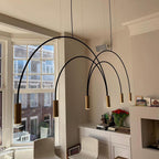 Long black arches and brass spot heads sweep out from this Clérachic pendant in a bay-window room with a fireplace.