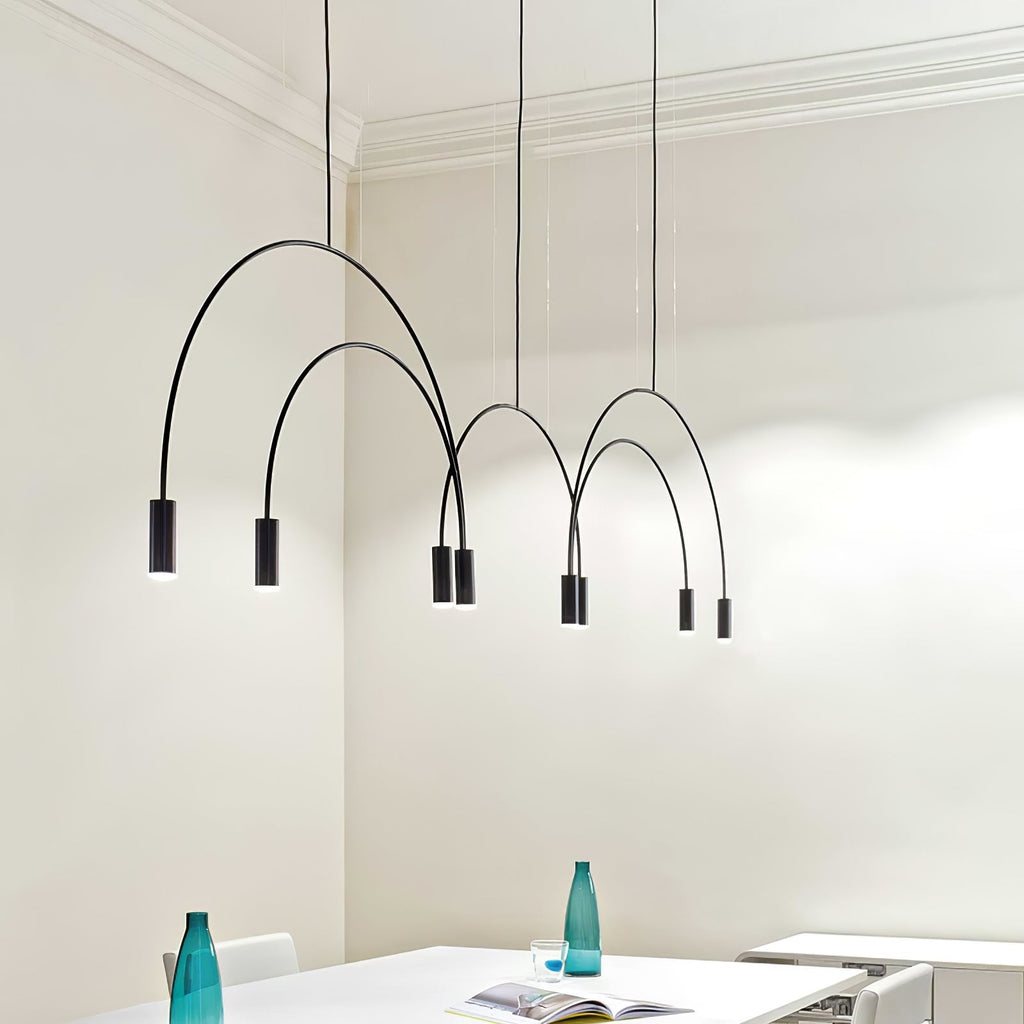 Black Clérachic arches and spot heads hang at different heights in a cream room with cornices, above a white table.