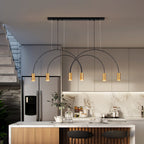 With a black canopy bar overhead, this Clérachic pendant lights a kitchen island with six warm brass spot heads.