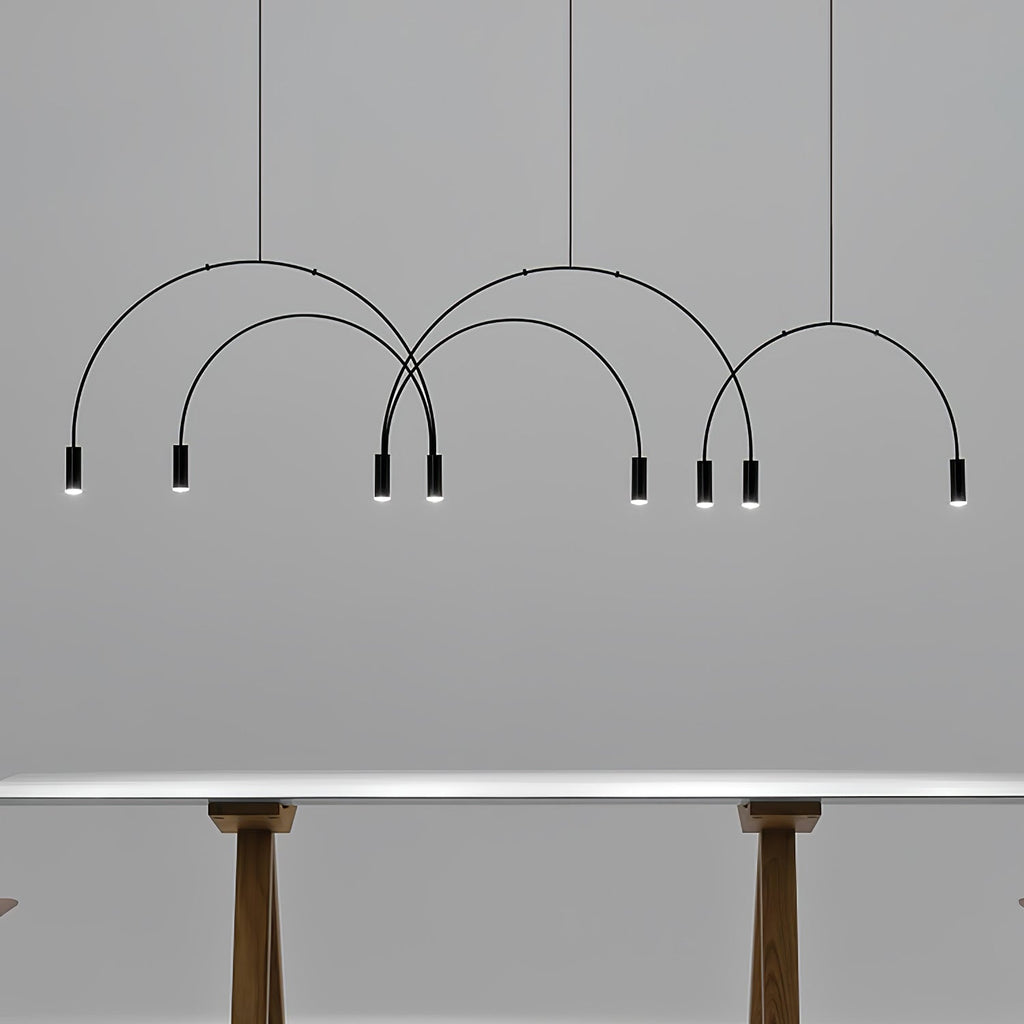 Black Clérachic spot heads and thin arches against a grey wall, with the legs of a table just visible below.