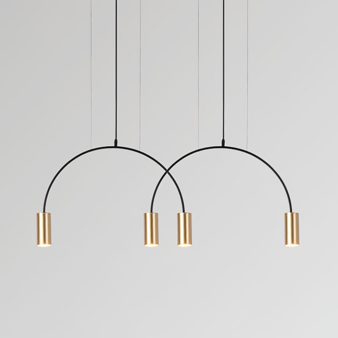 Two black arches and four brass spot heads, this Clérachic pendant hangs on a pale grey backdrop.