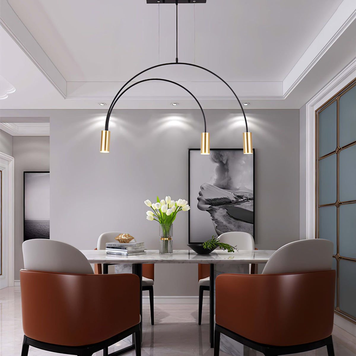 Over a marble dining table, this Clérachic pendant has two nested arches, three lit brass spot heads and a slim canopy.
