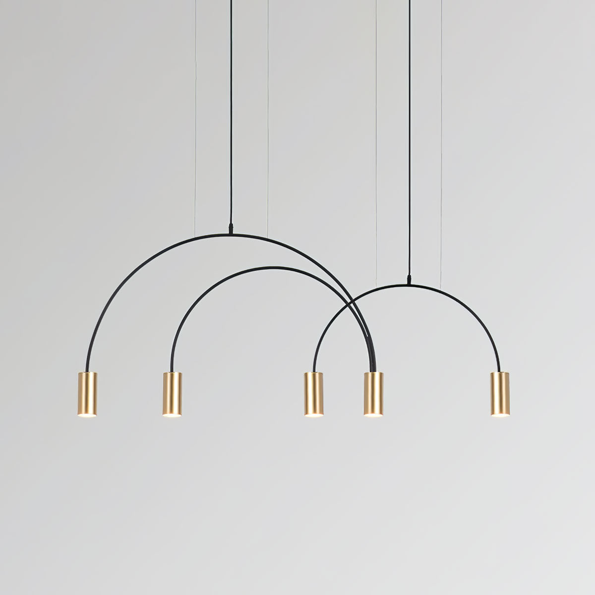 Five brass spot heads, with three arches stepping down in size, on this Clérachic pendant.