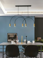 Brass spot heads and a black canopy bar, this Clérachic pendant hangs above a grey table against a blue wall.