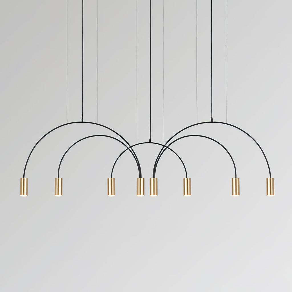 Eight brass spot heads on interlocking black arches, this Clérachic pendant on a pale grey backdrop.