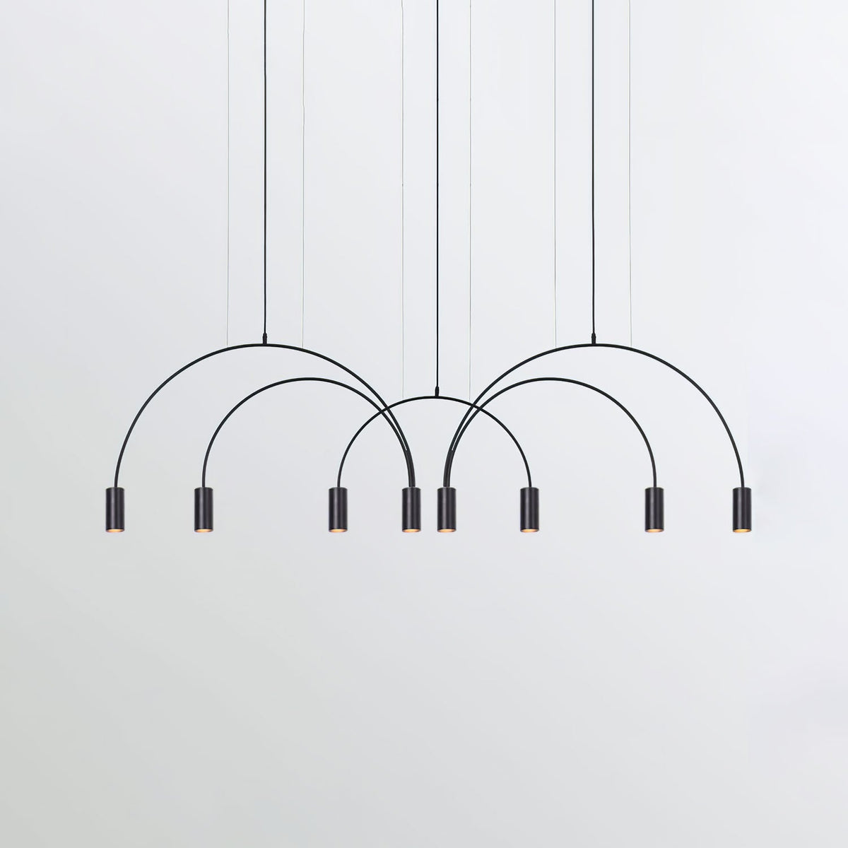 Eight black spot heads under overlapping black arches, this Clérachic pendant on a soft grey backdrop.