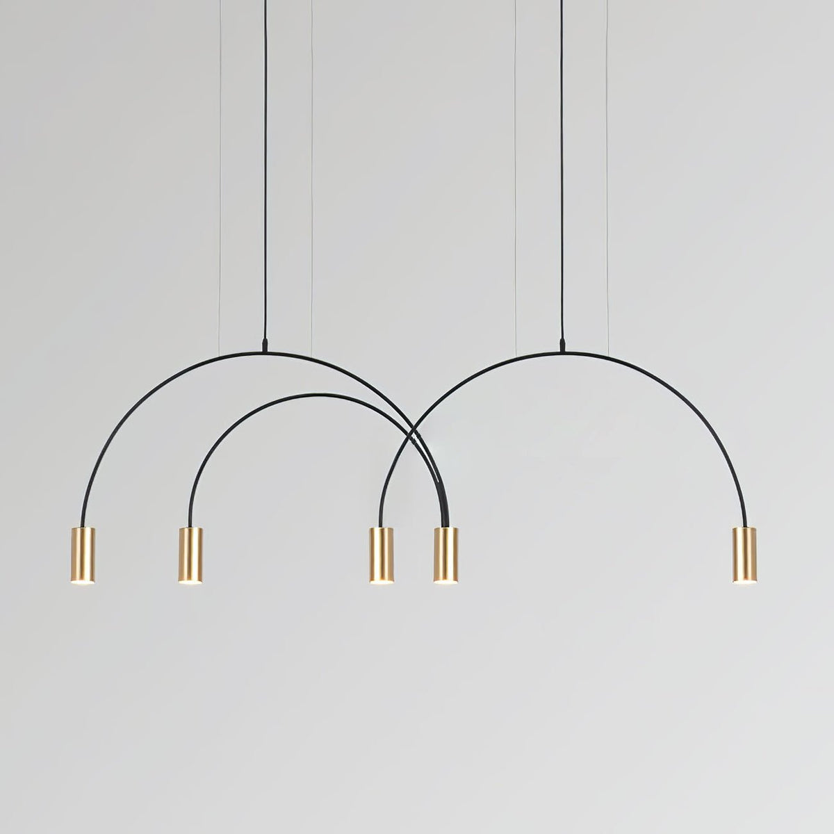 Five brass spot heads hang below three black arches of different heights on this Clérachic pendant.