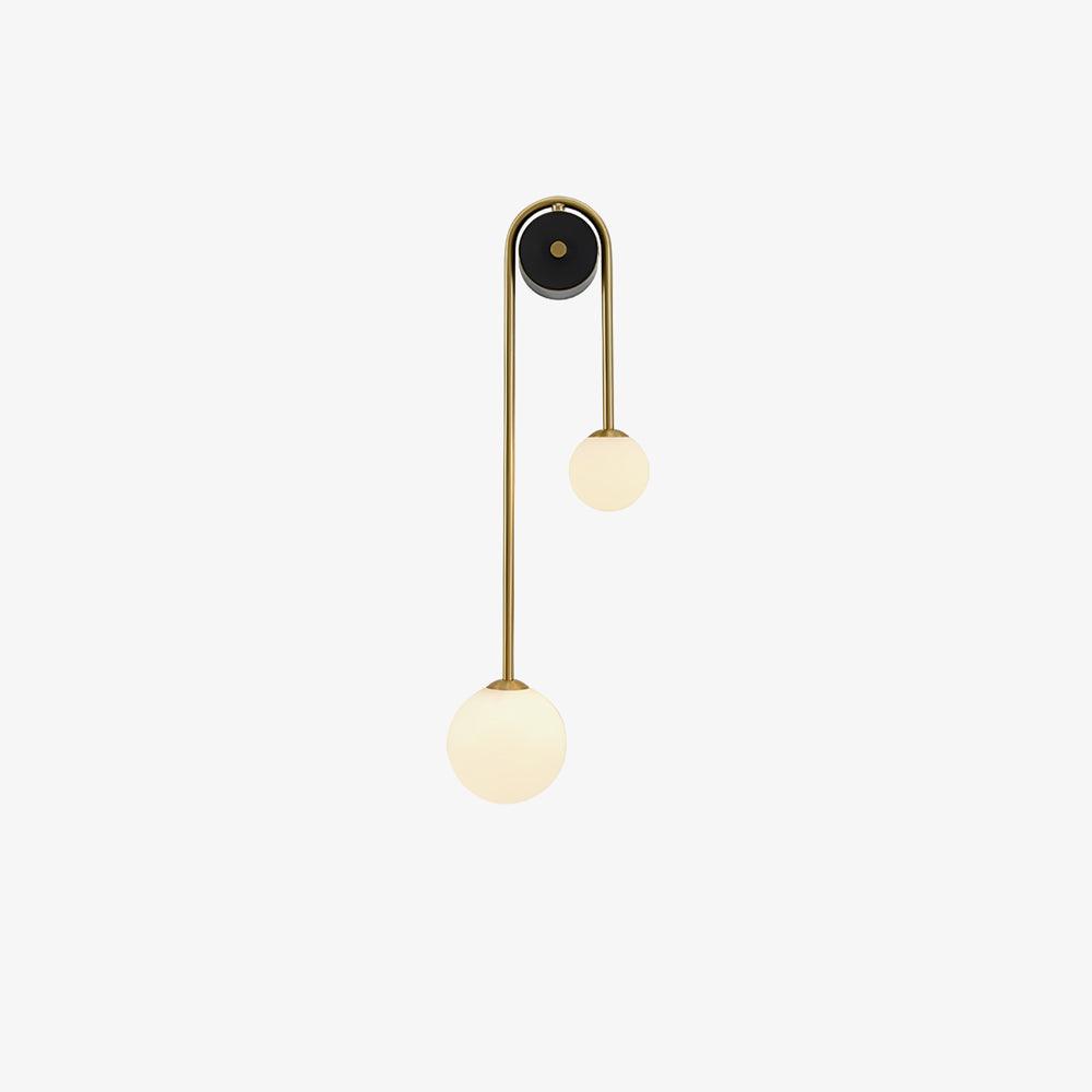 Clérachic arched brass wall sconce shown unlit, the milk-white globes flat matte against an off-white background.