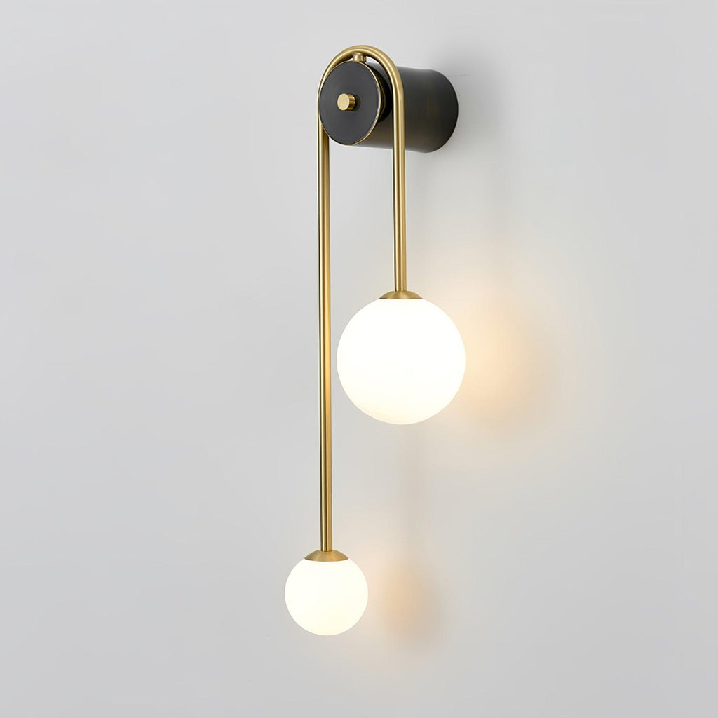 Clérachic arched brass wall sconce turned to show its depth, the brass tube arcing over from the black wall body.