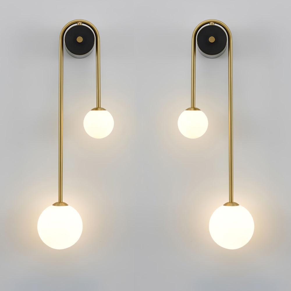 The two mirrored Clérachic arched brass wall sconces together, showing how the arcs curve away from each other.