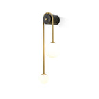 Three-quarter studio view of the Clérachic arched brass wall sconce, brass arc, black cylinder and two matte globes.
