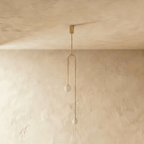 Clérachic gold arch pendant with two frosted globes switched off, hanging on a single stem from a gold canopy.