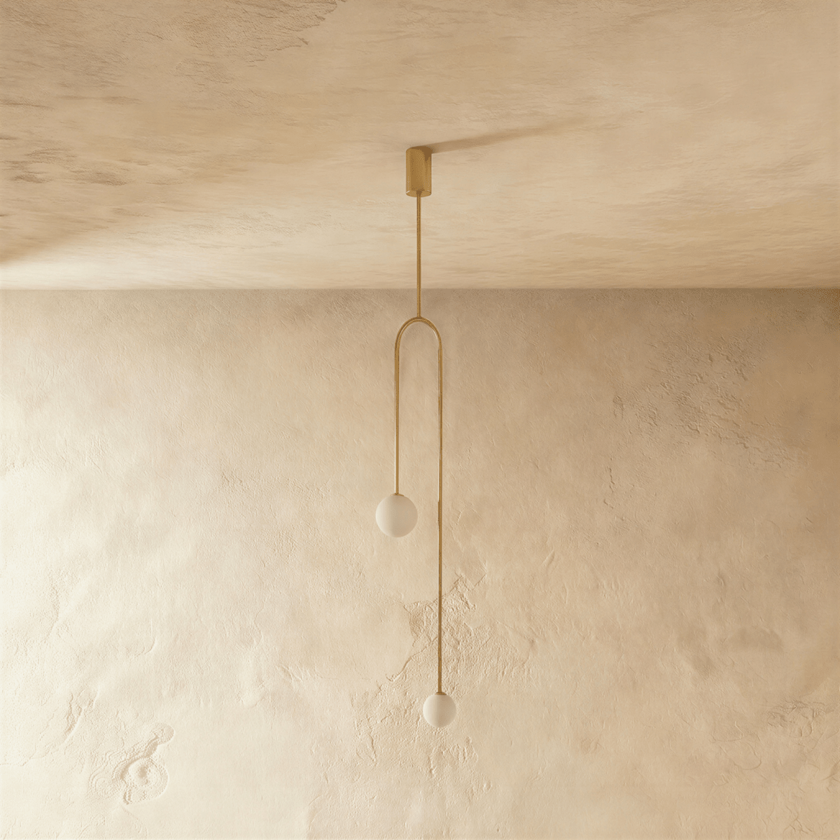 Clérachic gold arch pendant with two frosted globes switched off, hanging on a single stem from a gold canopy.