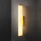 The Clérachic brass sconce seen straight on, alabaster panels showing their natural cloudy veining under warm light.