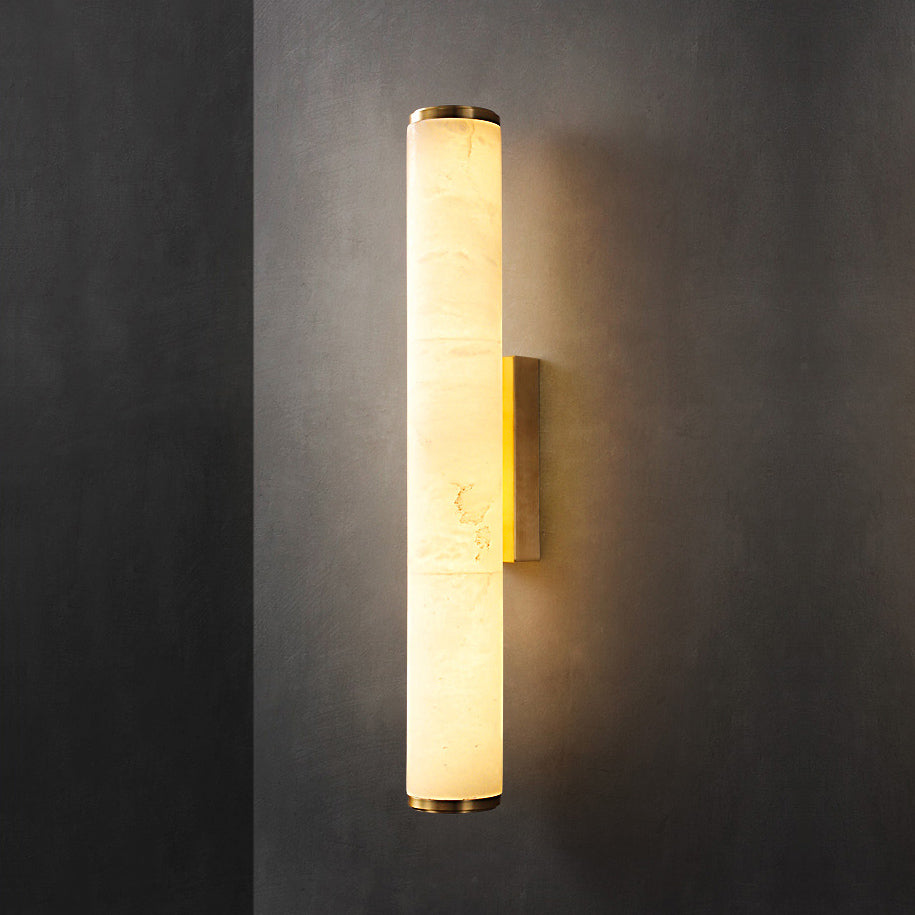 The Clérachic brass sconce seen straight on, alabaster panels showing their natural cloudy veining under warm light.