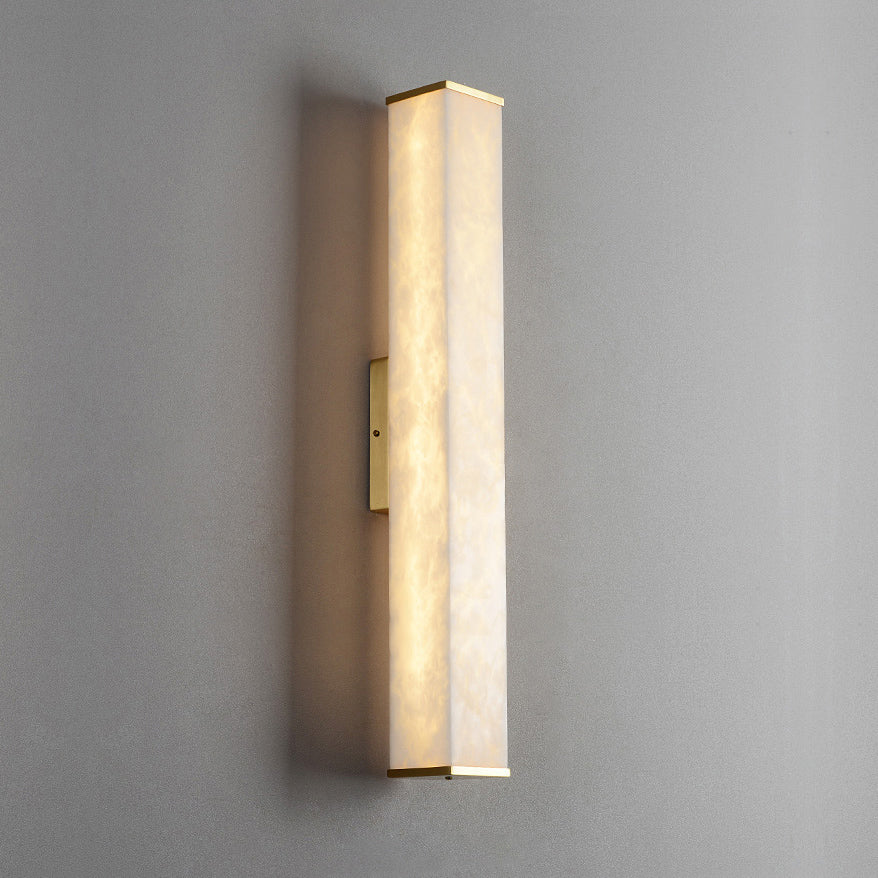 Clérachic squared alabaster sconce viewed at an angle, the slim brass backplate holding it flat to the wall.