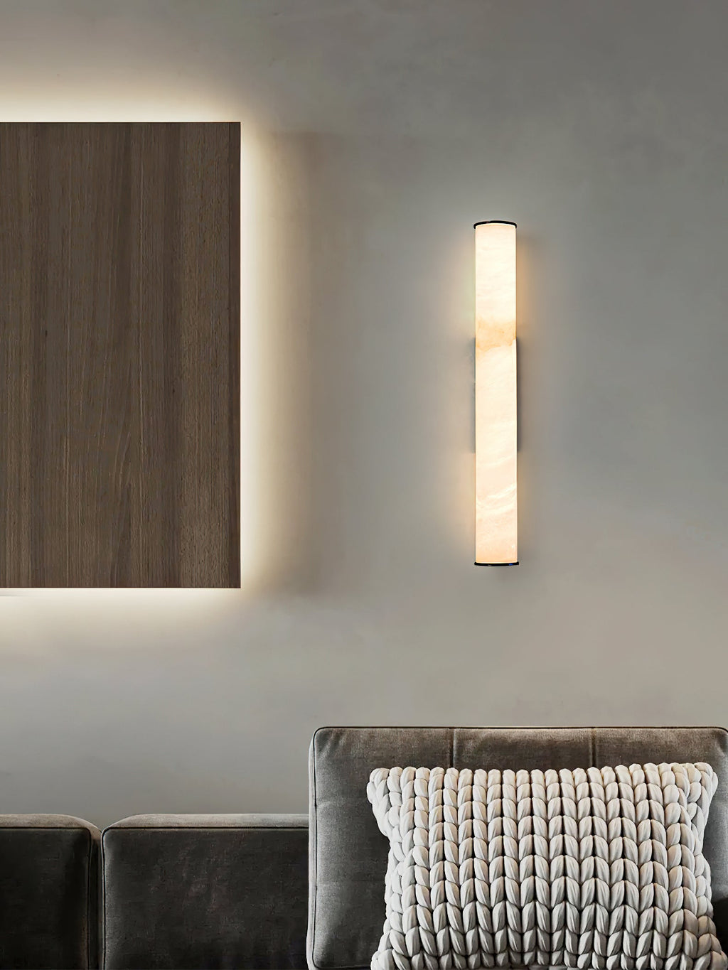 The Clérachic sconce as a slim vertical accent above a velvet sofa, alongside a backlit walnut wall panel.