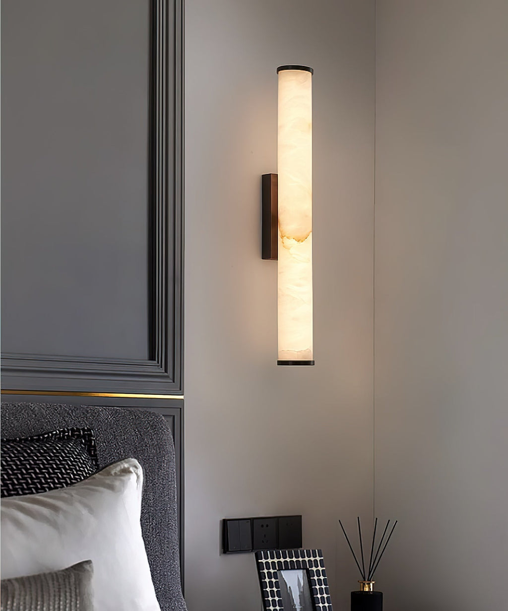 Clérachic sconce on grey panelled joinery, warm light falling across a reed diffuser and framed print.