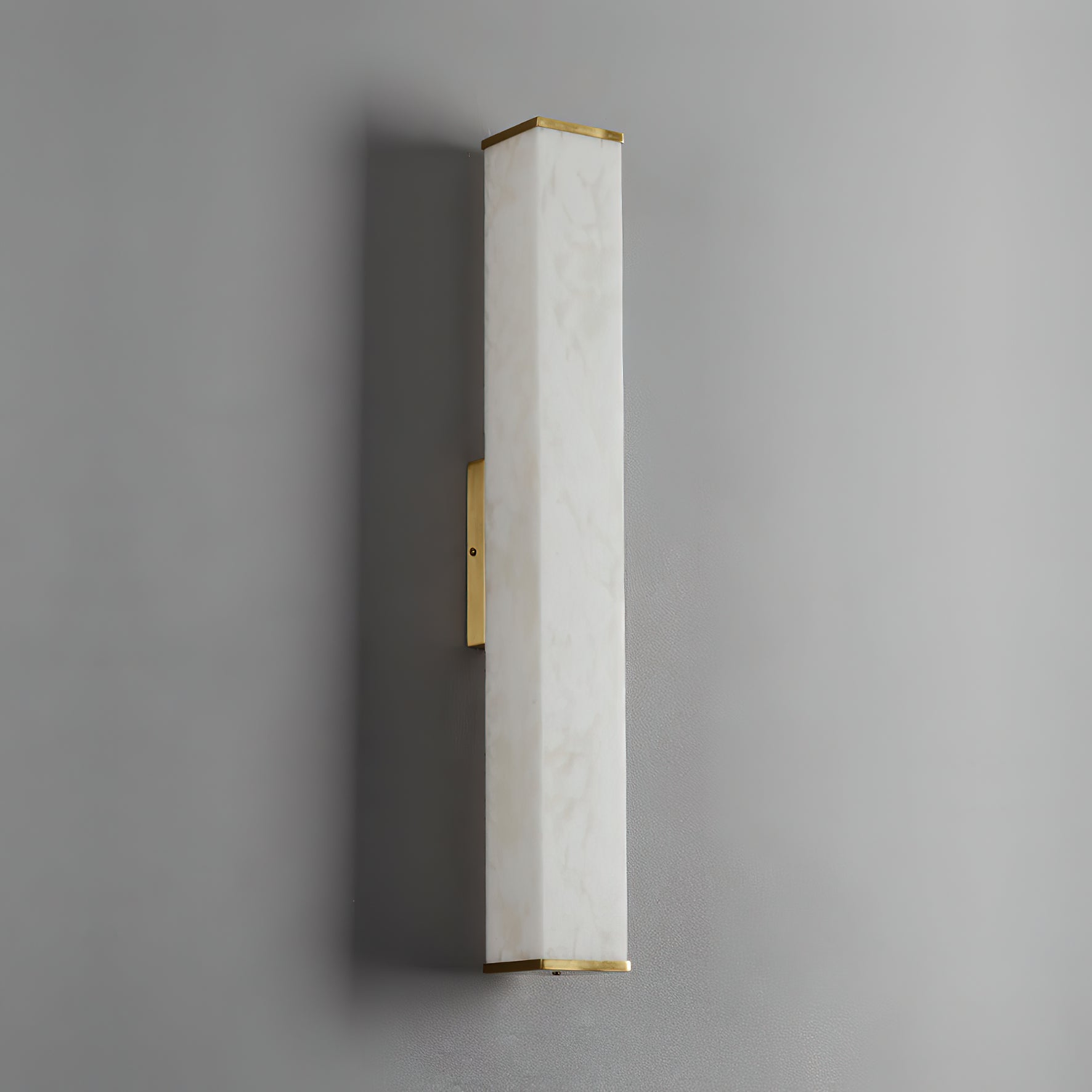 The Clérachic squared sconce unlit, showing the pale alabaster face and satin brass bar flat against grey.