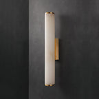 Clérachic alabaster sconce unlit on a dark charcoal wall, the brass bracket reading as a bright vertical line.