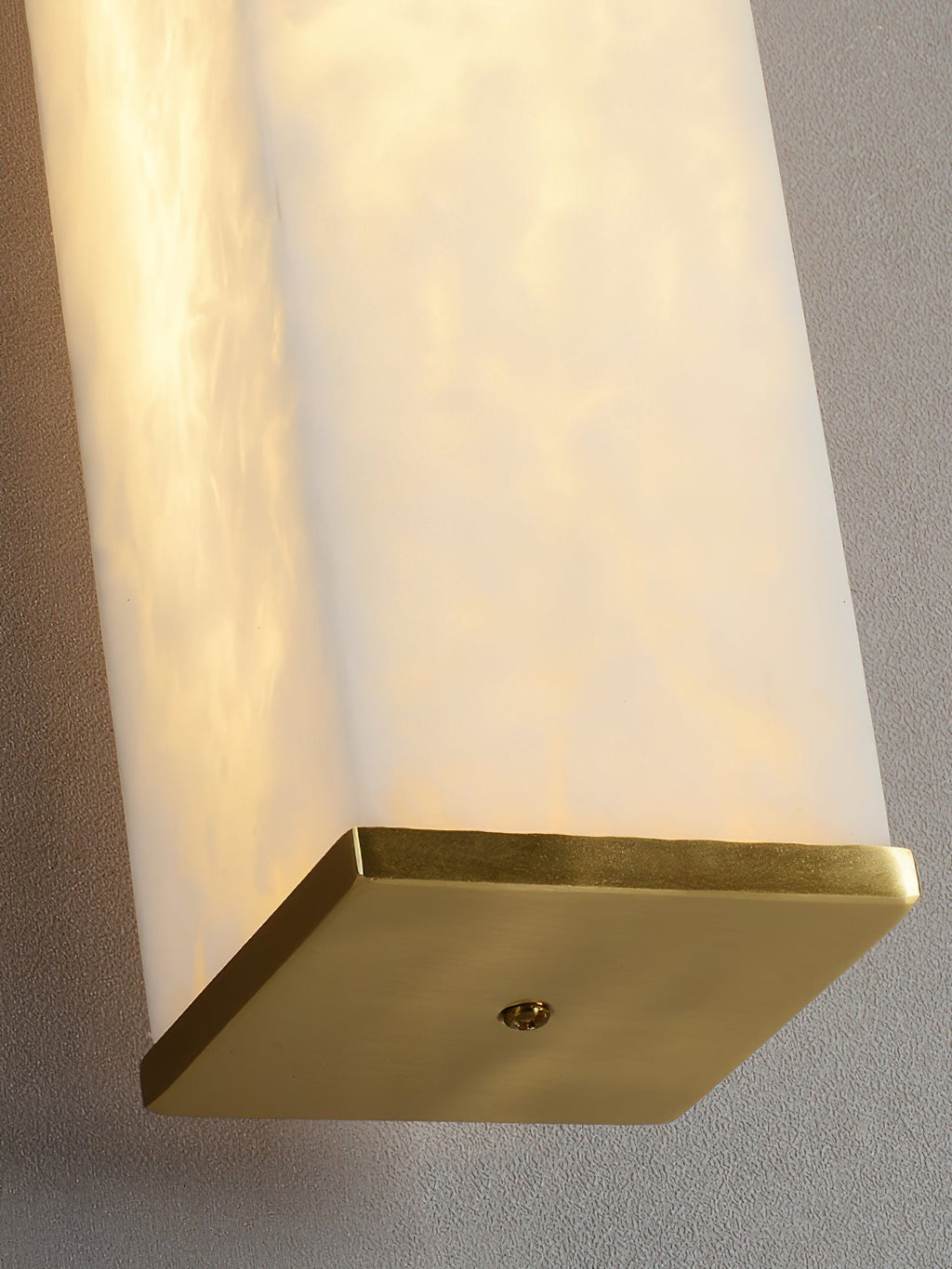 The Clérachic squared sconce from below, its brass backplate and fixing point set against the stone body.