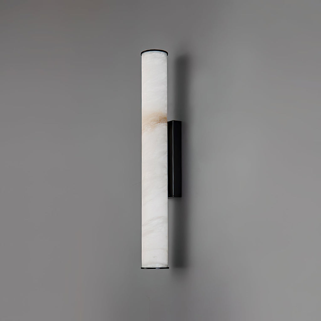 The Clérachic sconce in black, its full alabaster column shown flat-on against a soft grey studio wall.