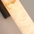 Macro of the Clérachic sconce's alabaster panel, honey-toned veining running beside the bronze bracket.