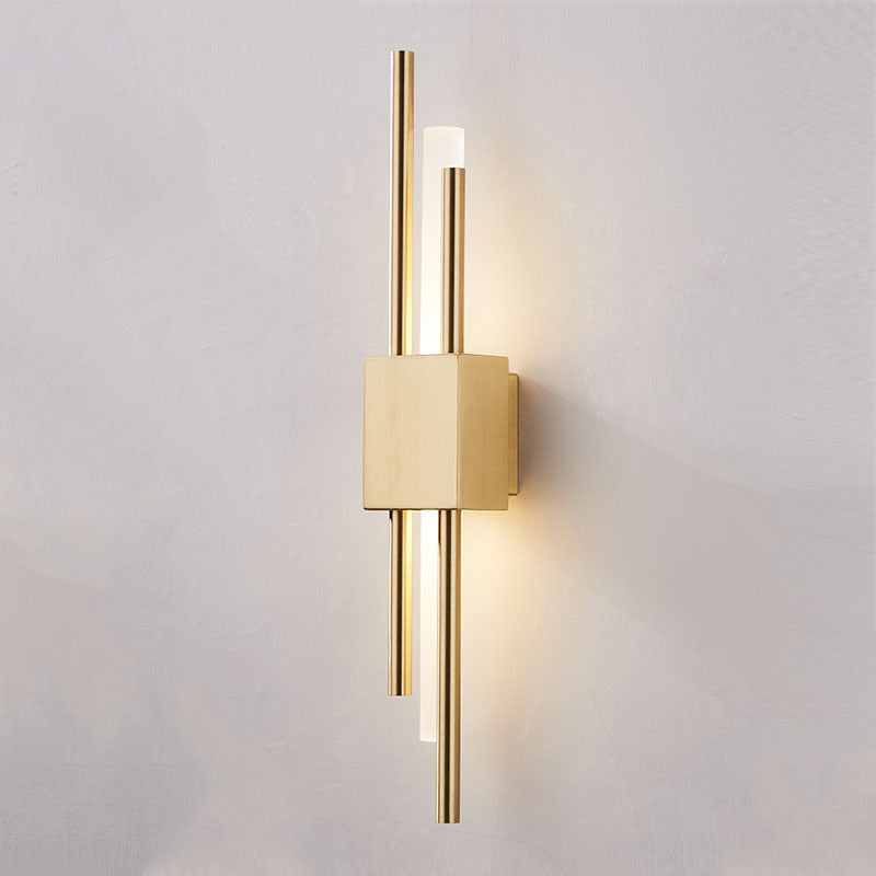 Clérachic gold wall light sconce seen at an angle, the mounting block standing proud on its back plate and casting a soft shadow.