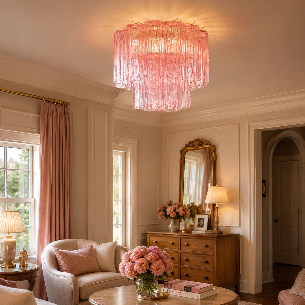 Pink art glass Clérachic flush mount hanging from the ceiling of a cream sitting room, with rose curtains, a gilt mirror and a bunch of peonies.