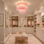 Pink Clérachic flush mount above a dressing room with built-in wardrobes, hanging clothes and a blush upholstered bench.