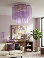 Purple Clérachic flush mount above a lilac-walled living room, with a cream sofa, a fiddle-leaf fig and an abstract painting.