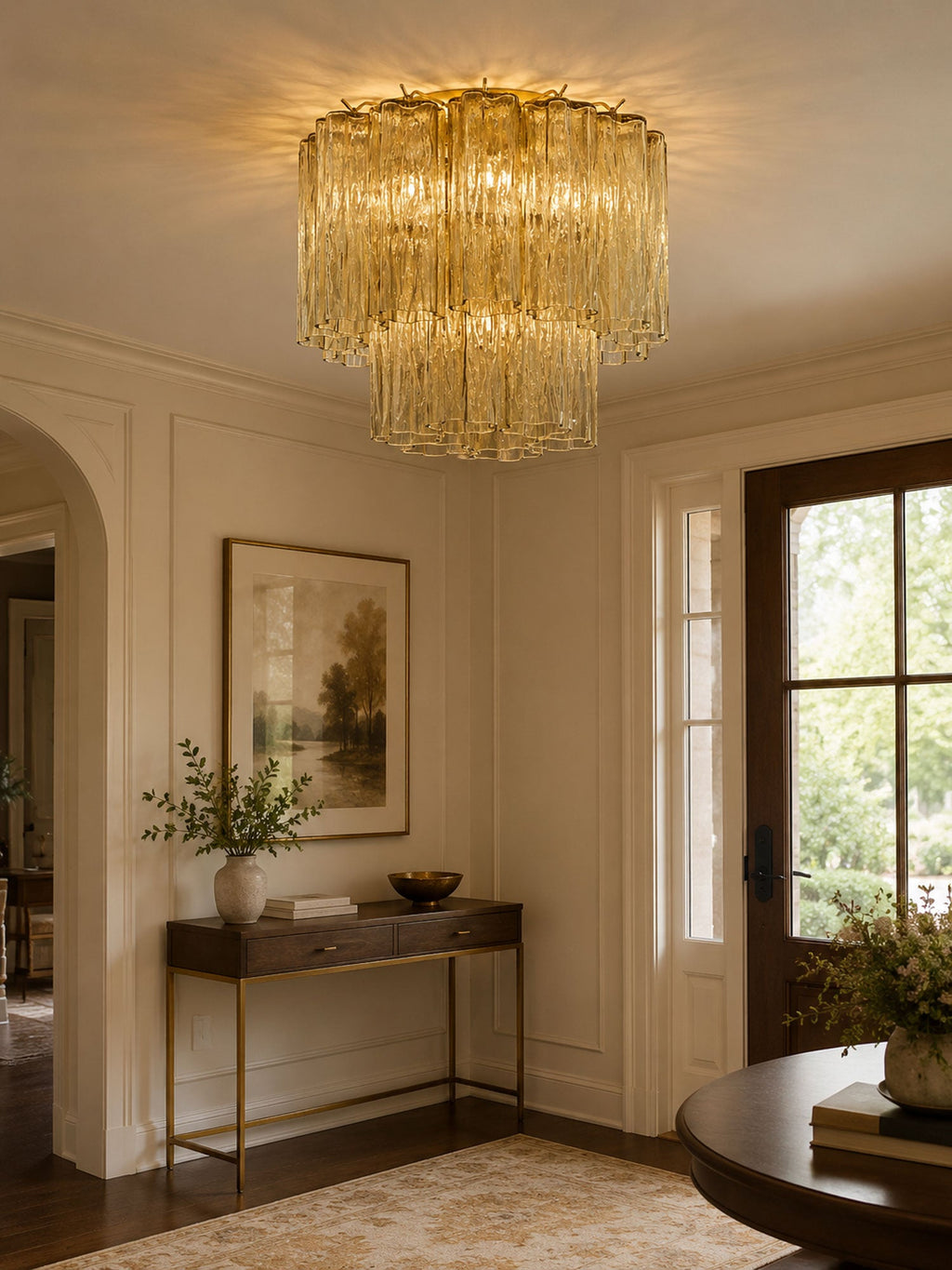 Pale champagne-yellow Clérachic flush mount in an entrance hall, with a slim console table, a landscape print and a glazed front door.
