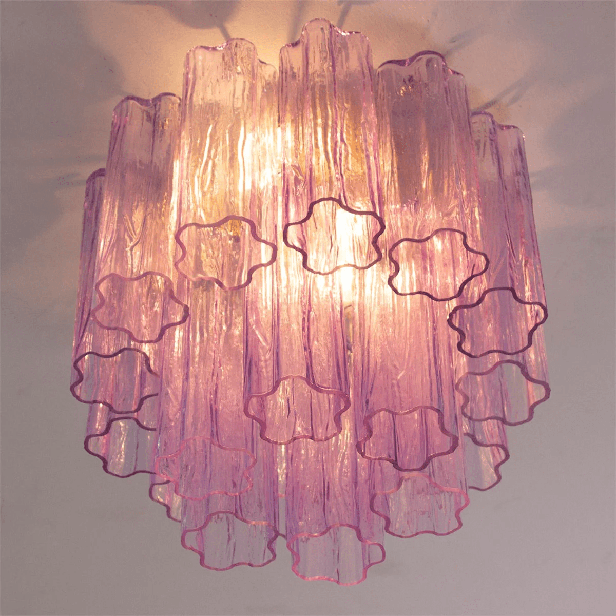 Looking up at the purple and pink glass tubes of this Clérachic flush mount, with the star-shaped ends of the tubes picked out.