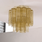 Olive-toned glass Clérachic flush mount with two tiers of textured tubes, hung from a white ceiling.