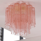 Looking up at the pink glass tubes of this Clérachic flush mount, fading from rose at the top to clear at the base.