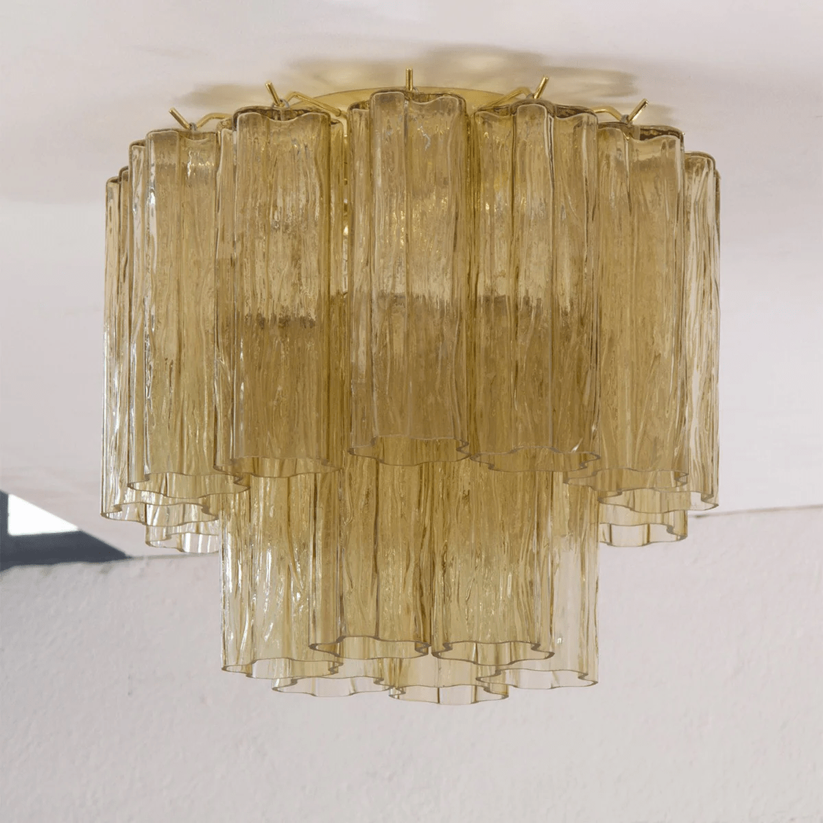 Straight-on view of this Clérachic flush mount in olive-gold glass, with textured tubes in two tiers against a white ceiling.