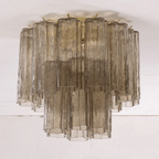 Smoky grey glass Clérachic flush mount with textured tubes in two tiers, seen against a white ceiling.