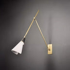 Clérachic wall light on a dark grey wall, with the white cone shade angled down and its rolled edge catching the light.