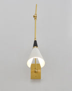 Front view of a Clérachic wall light with the arm raised straight, the white cone shade lit inside and a brass backplate at the base.