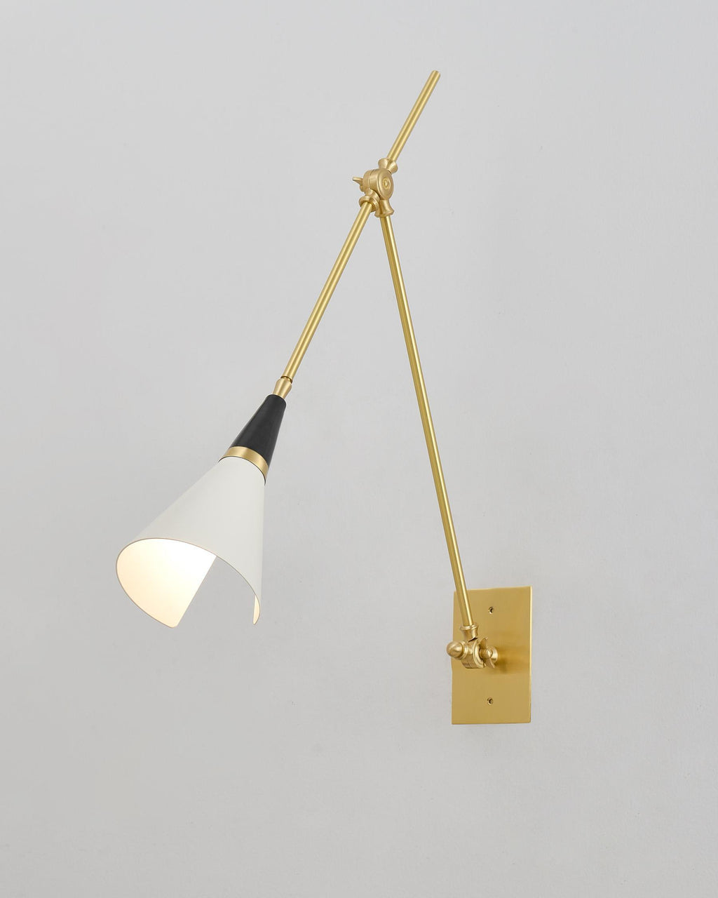 Clérachic wall light with a white cone shade turned inward, on a pale wall that meets a corner on the left.