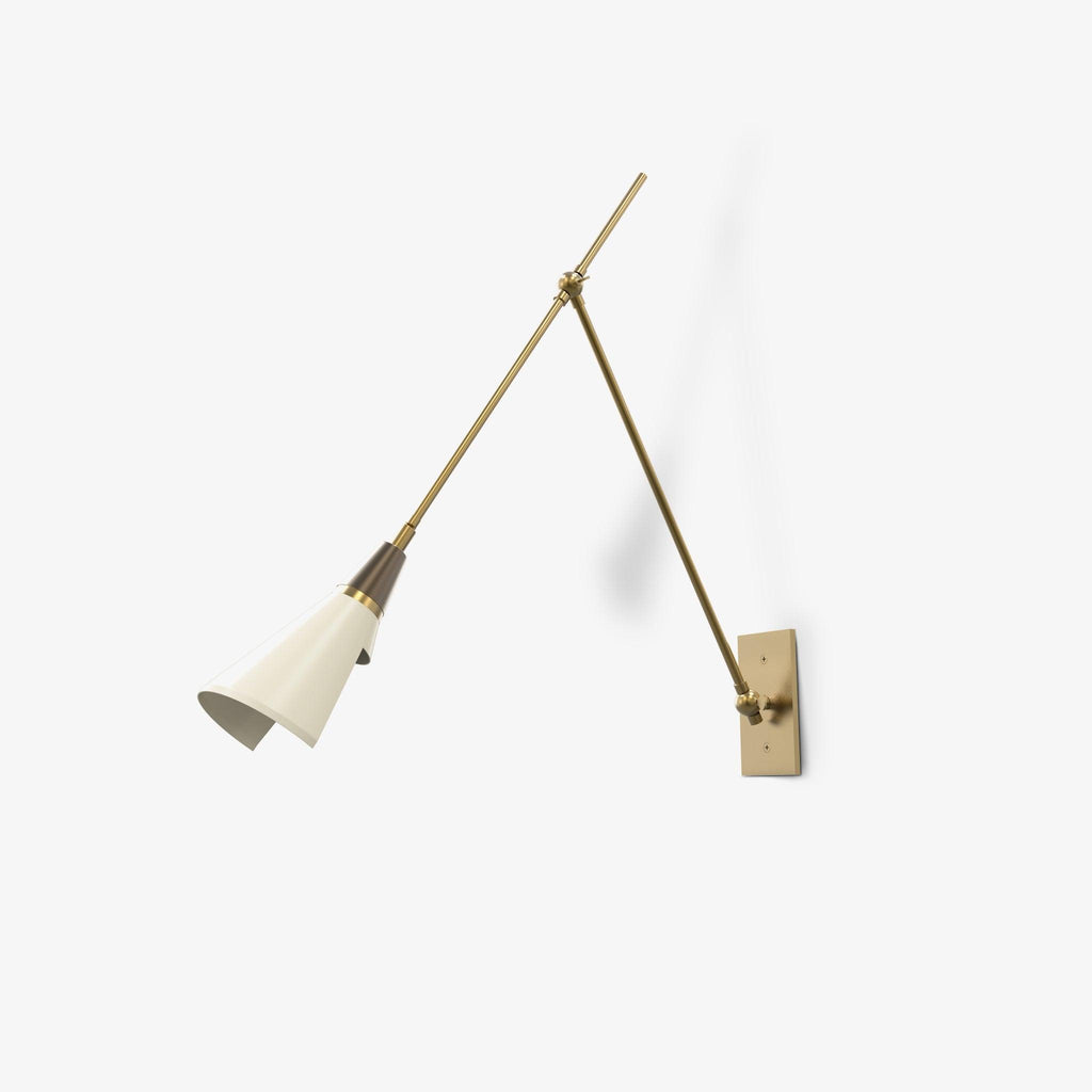 Clérachic wall light on a white backdrop, with a cream-white shade, a dark neck and long brass arms reaching to a small backplate.
