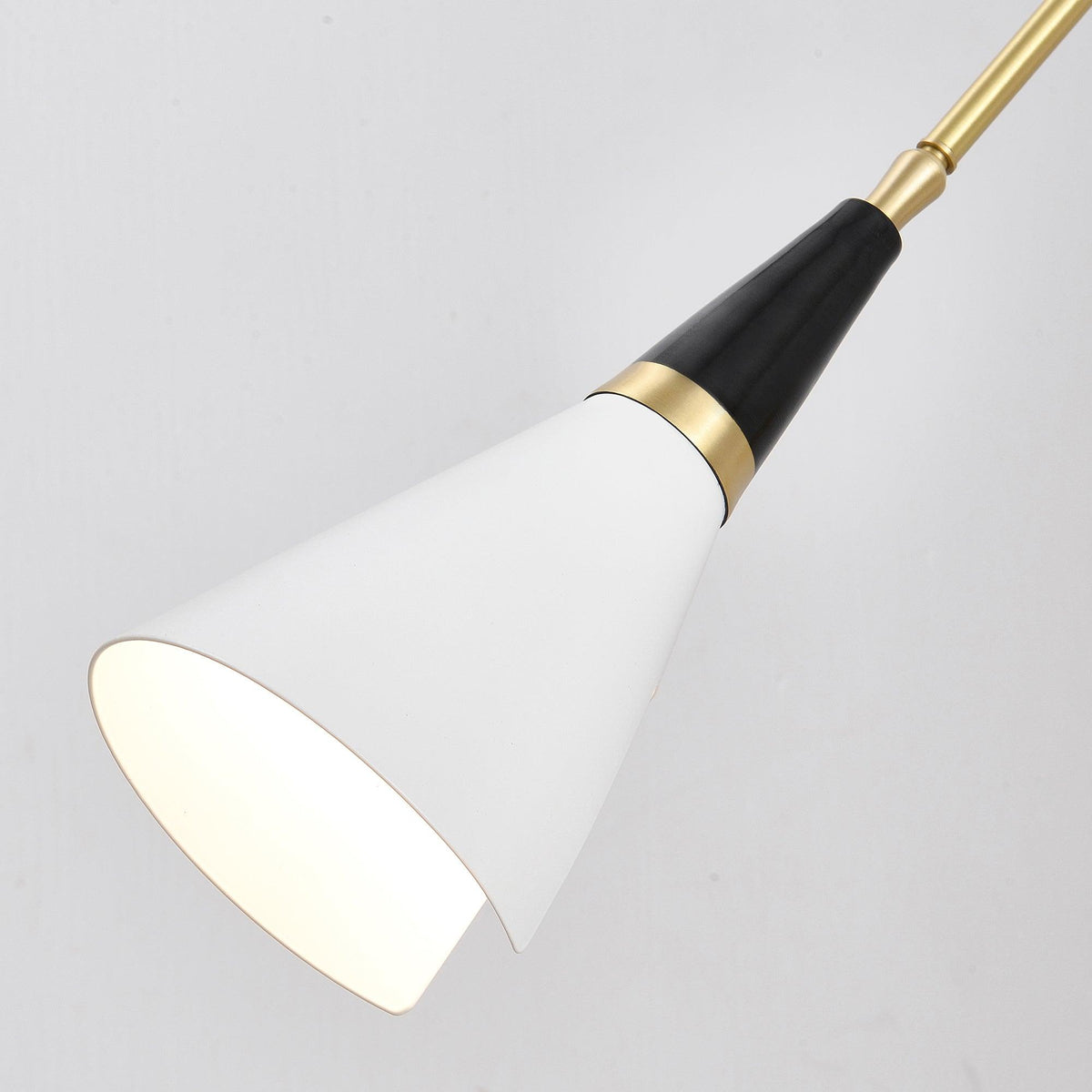 Large close view of the white cone shade, black neck and brass collar on this Clérachic wall light, seen from inside the open rim.