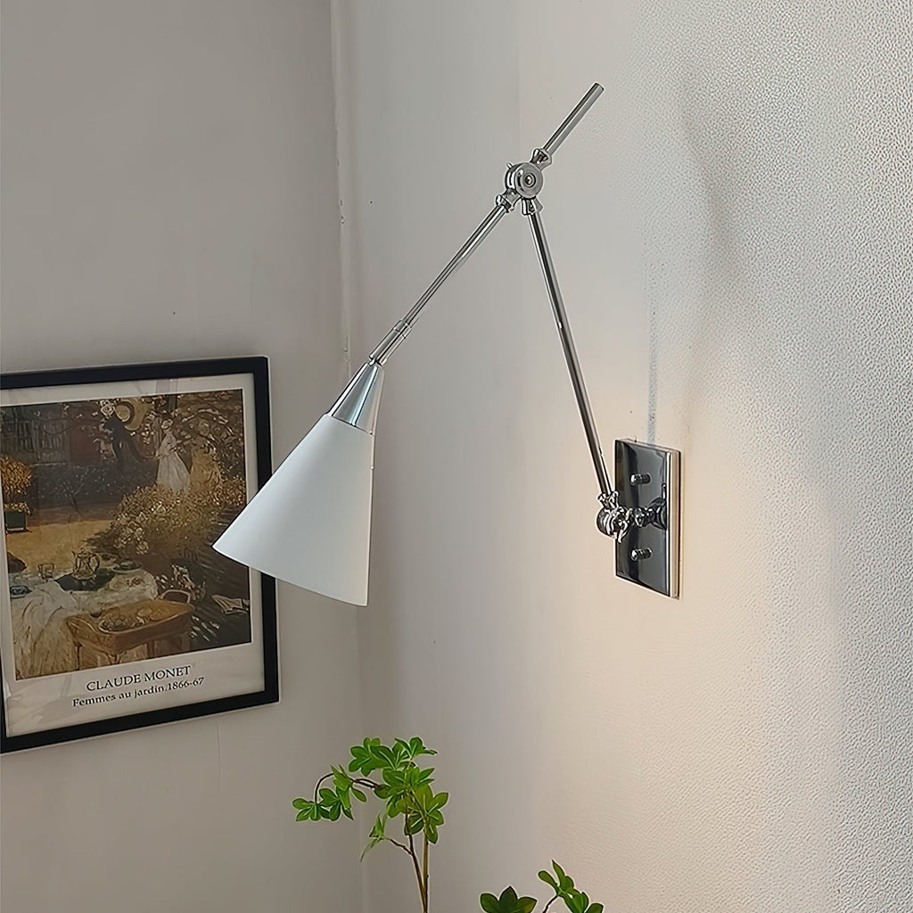 Clérachic wall light in bright nickel, with a white cone shade and a dark backplate, beside a framed garden print and a green plant.