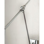 Close view of the bright nickel arm joint on this Clérachic wall light, with one arm leaving the frame on a pale wall.