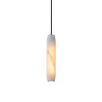 The Clérachic Asbury alabaster pendant on plain white, its slim stone shade lit warm with natural veining running through.