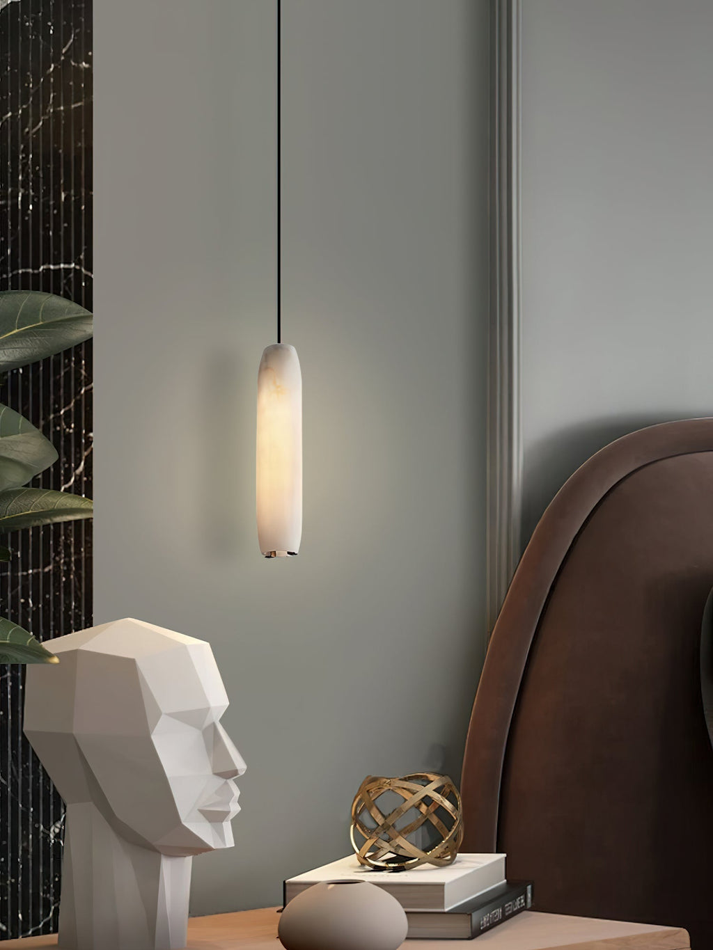 Clérachic pairs the Asbury with a brown leather headboard, its glow falling on a white stone face sculpture and books.